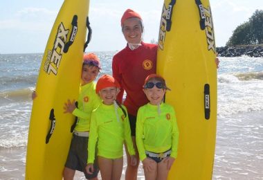Group of junior Nippers on the beach with lifesavers